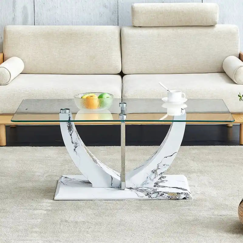 Moderner minimalistischer Couchtisch aus transparentem Hartglas mit MDF-Beinen in Marmoroptik und dekorativen Säulen aus Edelstahl